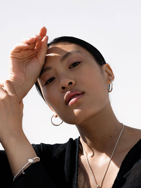 PURELEI Timeless Ohrringe aus recyceltem Silber, minimalistisch elegant, getragen im natürlichen Licht, feminine Ästhetik.