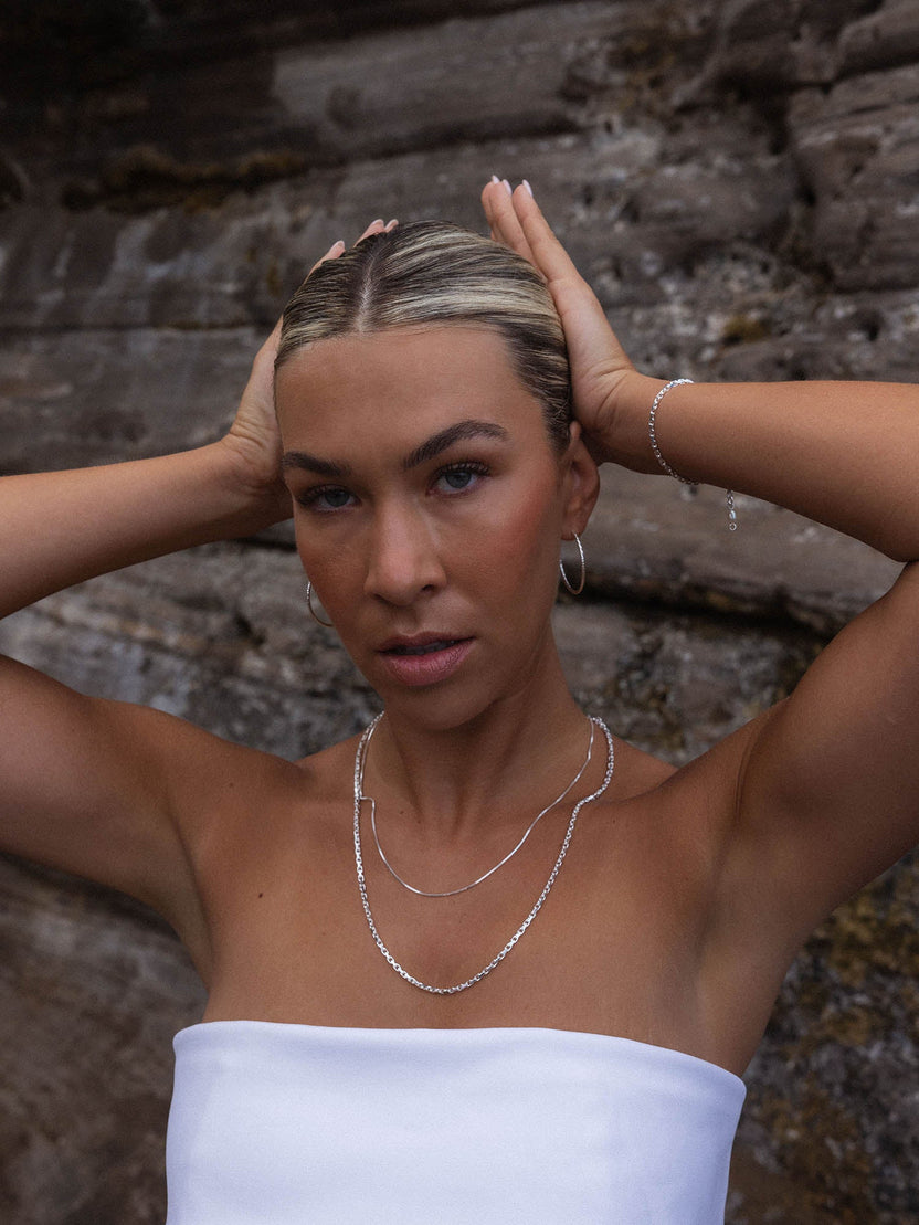 Perfection Kette aus recyceltem Silber mit schimmernder Süßwasserperle, getragen vor Felskulisse – PURELEI.