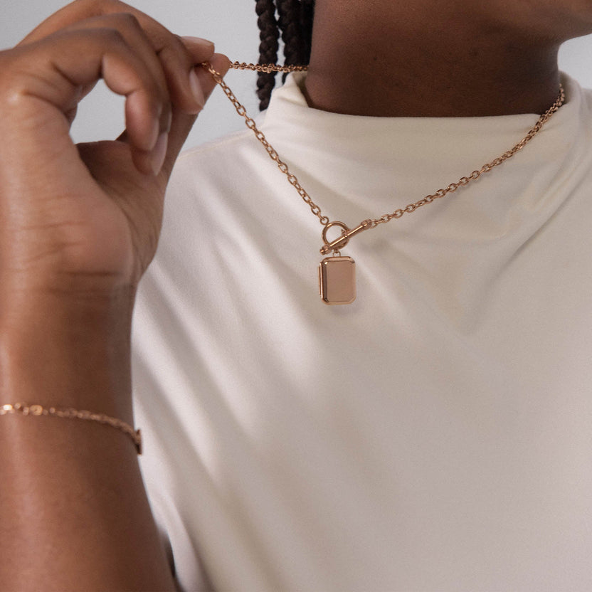 Roségoldene Kette mit Anhänger, elegant und feminin, getragen auf hellem Stoff – PURELEI.