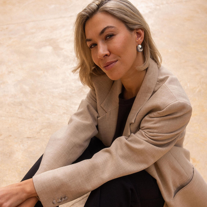 Elegante Ohrringe aus Silber, getragen von einer Frau in beigem Blazer, PURELEI.