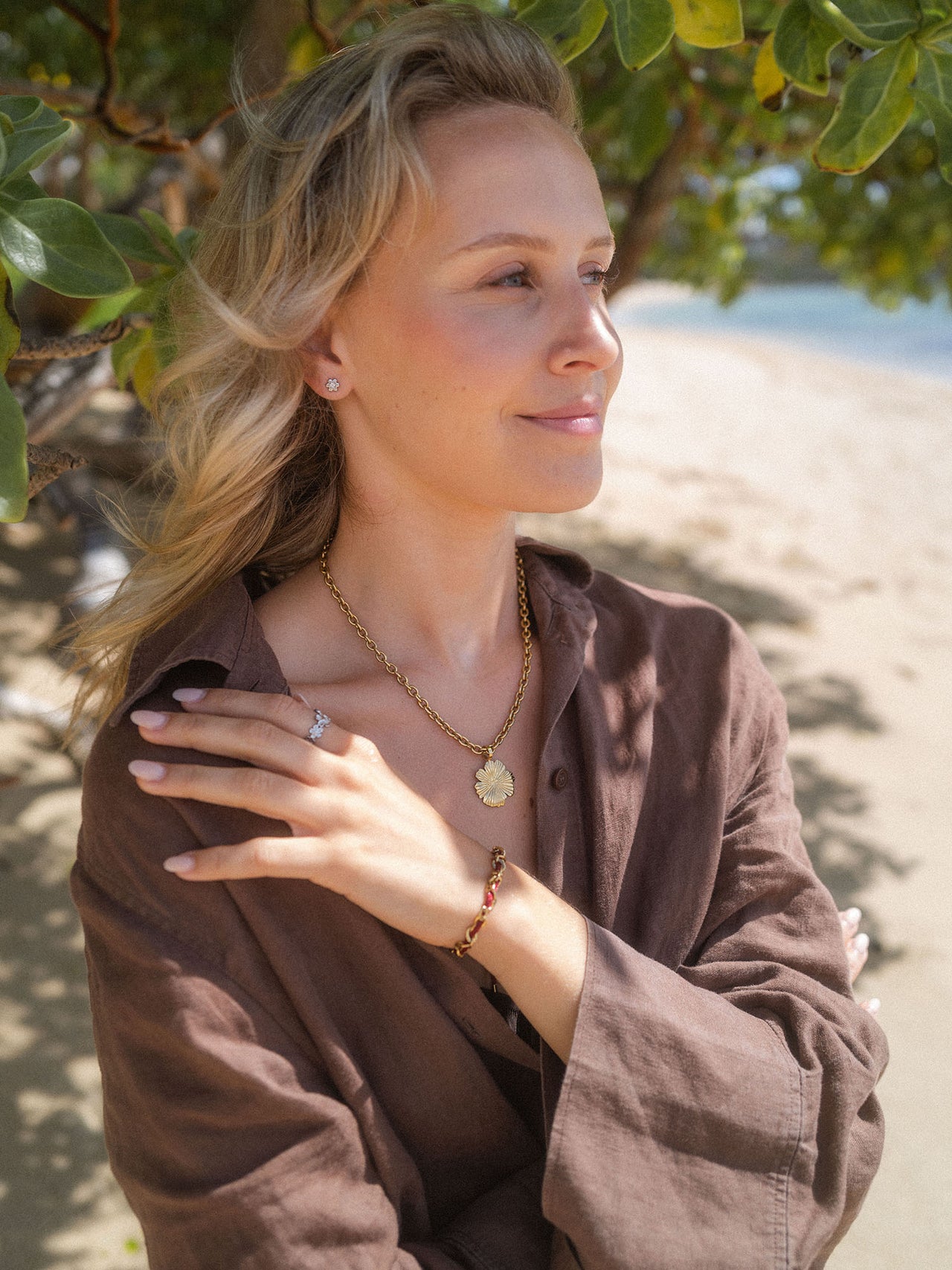 Roségoldene Kette mit Blütenanhänger und Armband, PURELEI, in natürlicher Umgebung.
