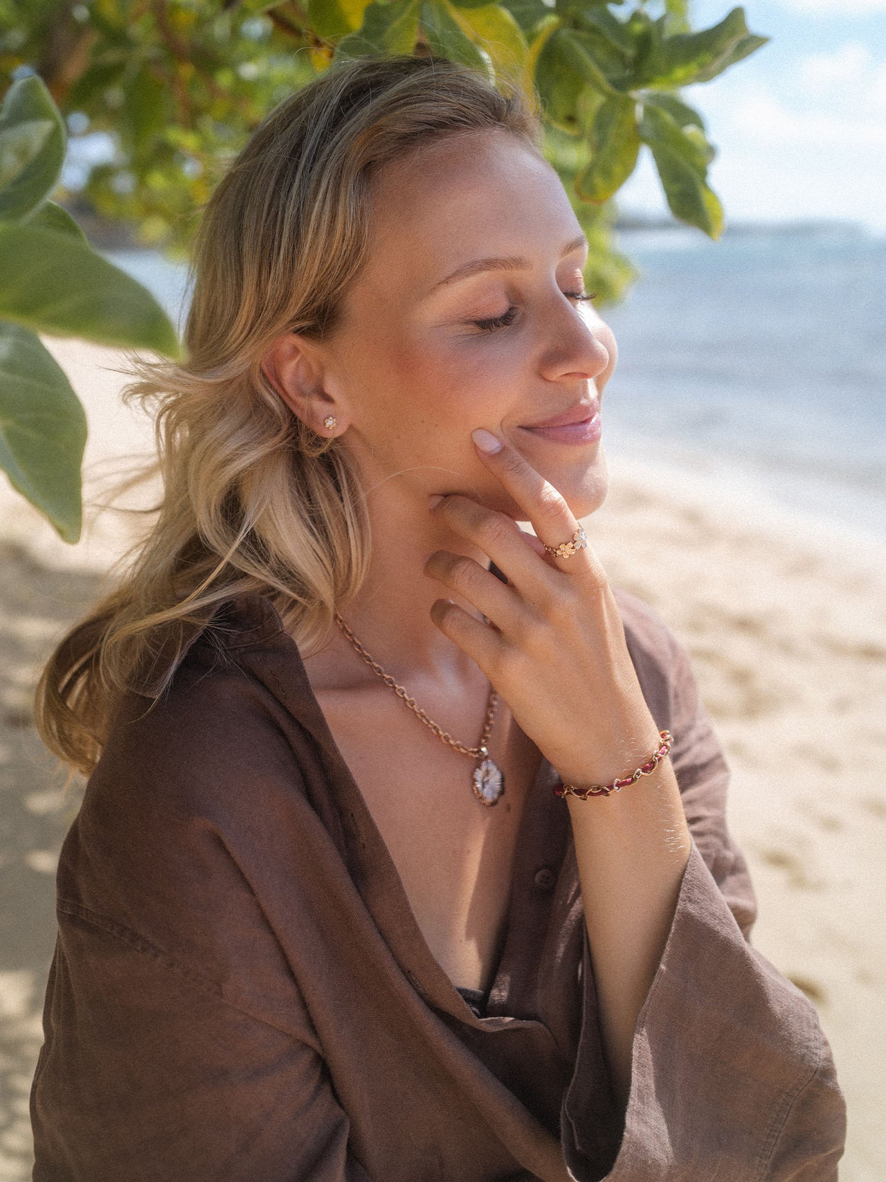 PURELEI Kette mit Anhänger und Armband, goldfarben, elegant am Strand getragen.