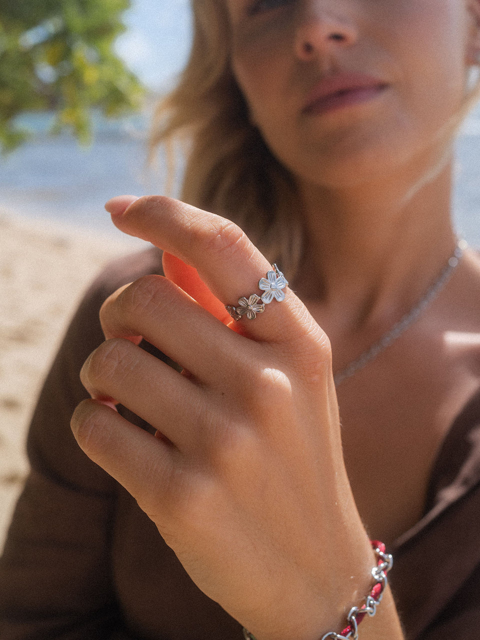 Silberner Ring mit blühendem Design, getragen am Strand, von PURELEI.