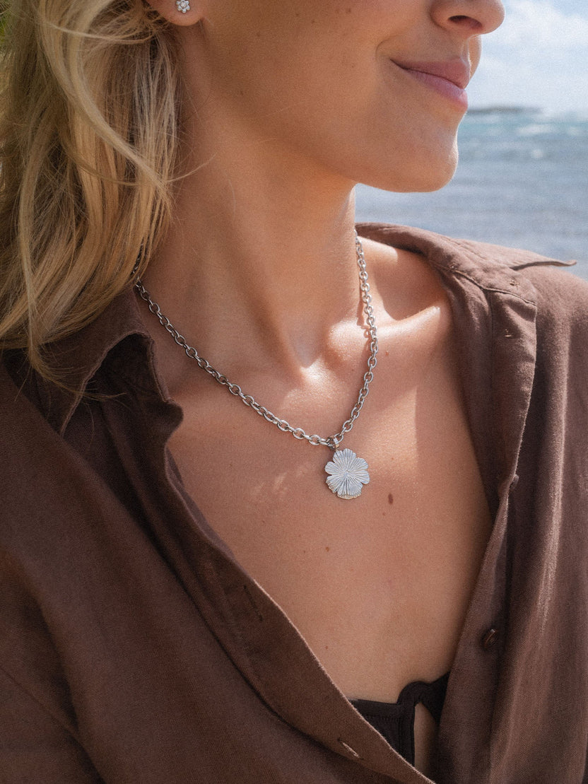 Silberne Kette mit floralen Anhänger, getragen in tropischer Umgebung – PURELEI.