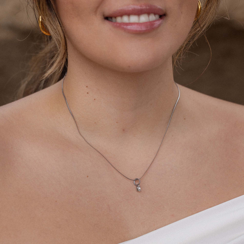 Silberne Kette mit zartem Anhänger, getragen in natürlicher Umgebung – PURELEI.