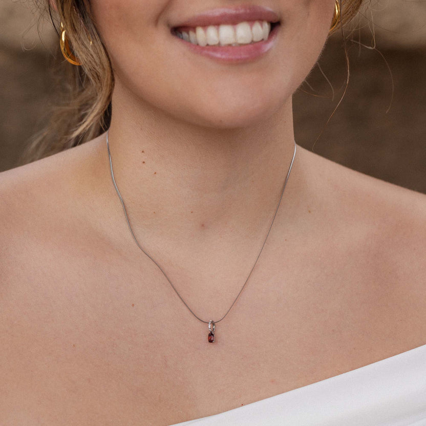 Silberne Kette mit braunem Anhänger, getragen mit einem Lächeln, PURELEI inspiriert.