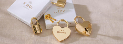 Goldene Liebesschlösser von PURELEI auf hellem Stoff, romantische Stimmung mit personalisierten Details.