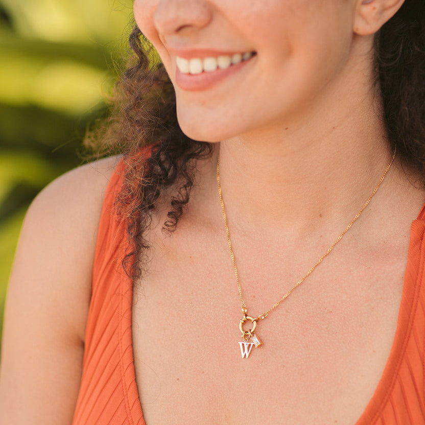 PURELEI Pure W Charm Anhänger aus goldfarbenem Edelstahl, elegant und feminin getragen am Hals.