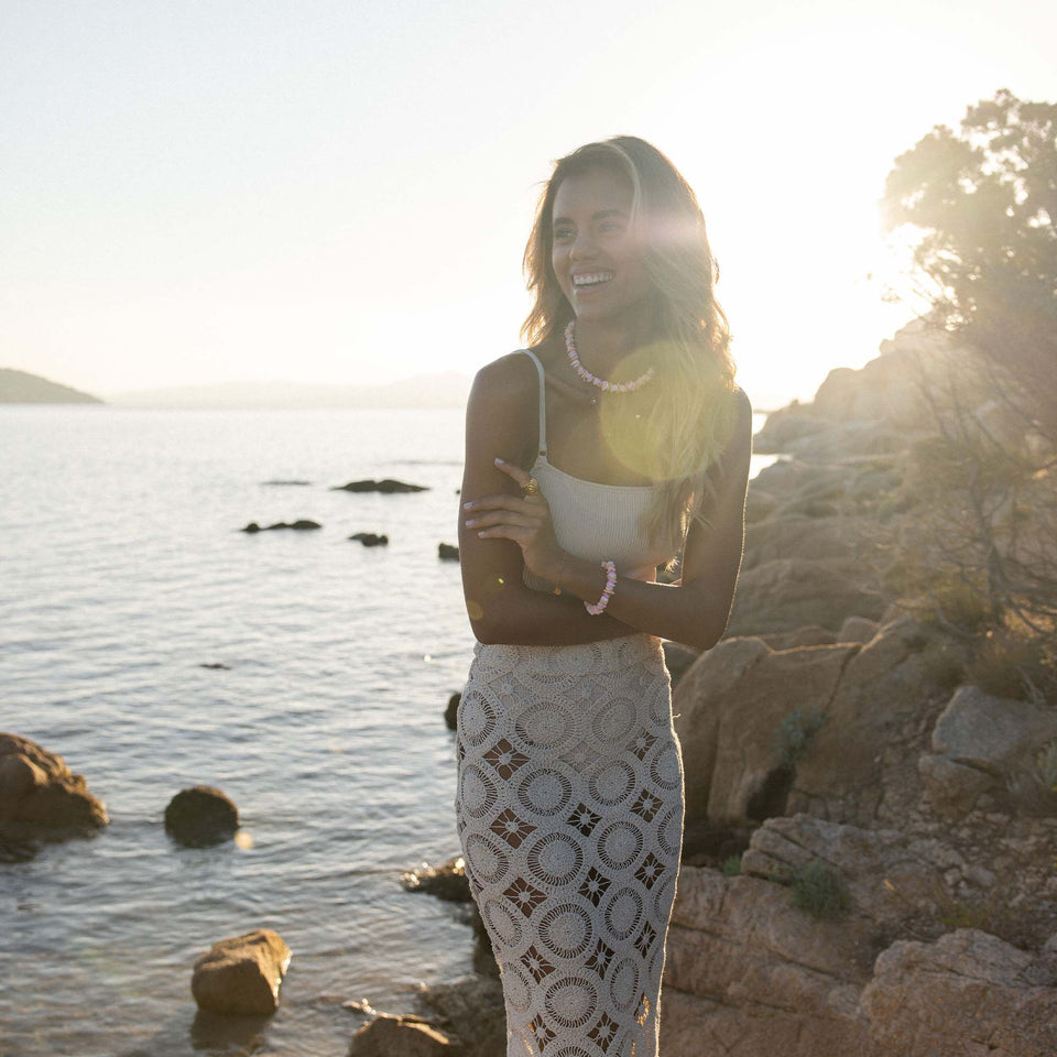 Summer Fußkette von PURELEI mit goldenen Anhängern und Perlen am Strand, elegant und feminine Urlaubsstimmung.