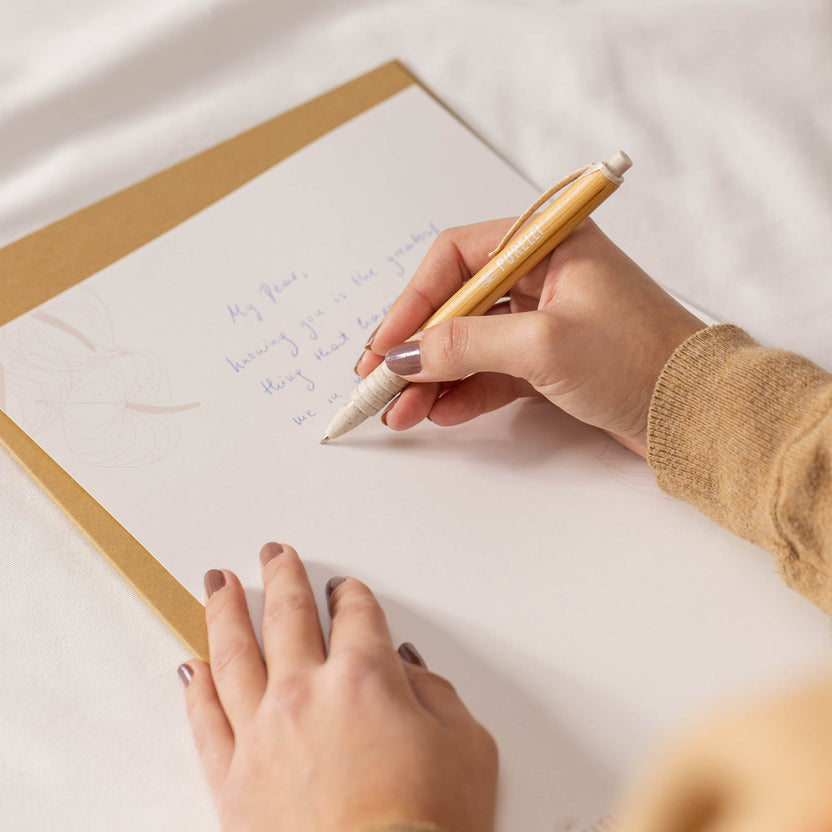 Eleganter Stift in Gold auf weißem Papier, inspiriert von PURELEI, mit warmem, kreativen Flair.